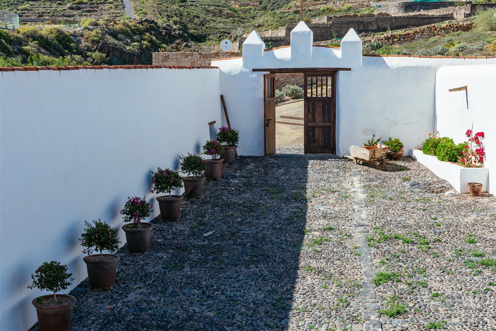 El paseo de entrada mirando desde dentro hacia fuera, se muestran los rasgos típicos canarios como el techo, la cantería, las paredes y las puertas.